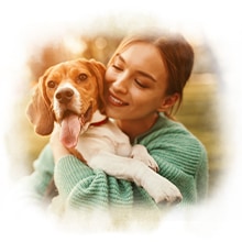 Hund auf den Armen Eine Frau hat einen Hund auf den Armen